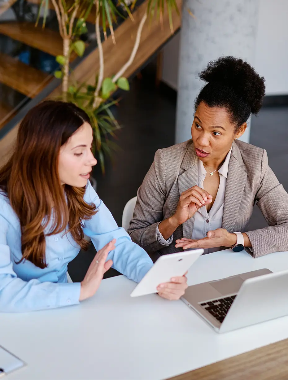 Two women sitting at a table, engaged in conversation